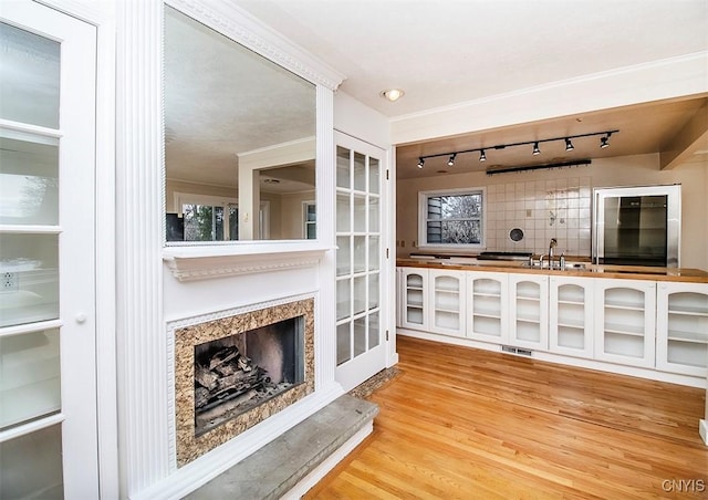 interior space with visible vents, a sink, a fireplace with raised hearth, and wood finished floors