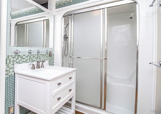 bathroom featuring a stall shower, decorative backsplash, tile walls, and vanity