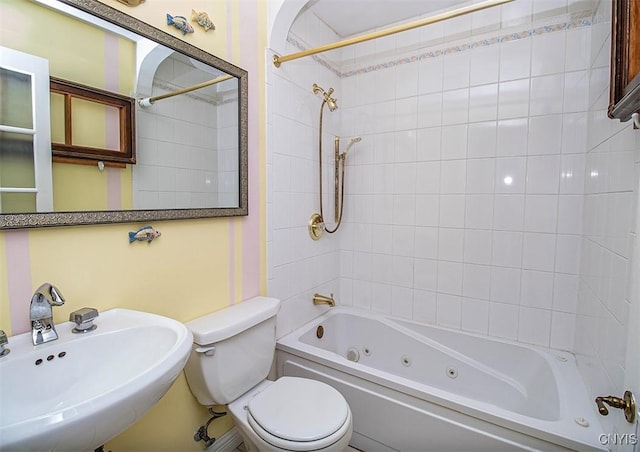 bathroom featuring a combined bath / shower with jetted tub, a sink, and toilet