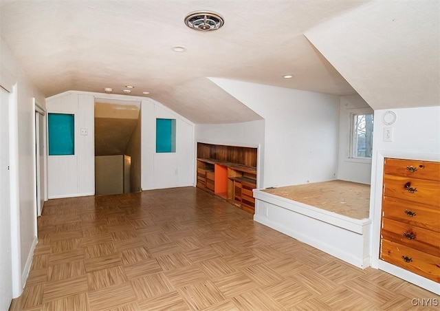 additional living space featuring vaulted ceiling and visible vents