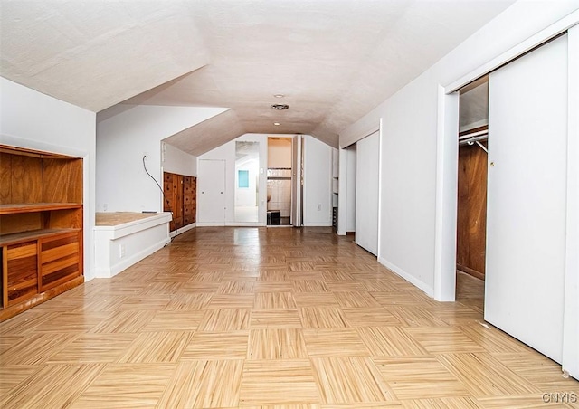 additional living space featuring lofted ceiling and baseboards