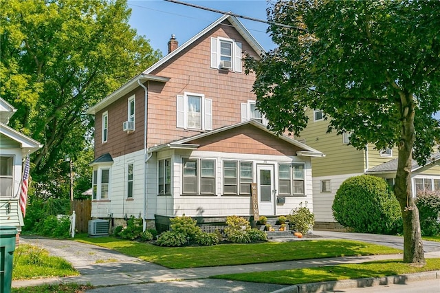 view of front of property featuring cooling unit, driveway, a chimney, and central air condition unit