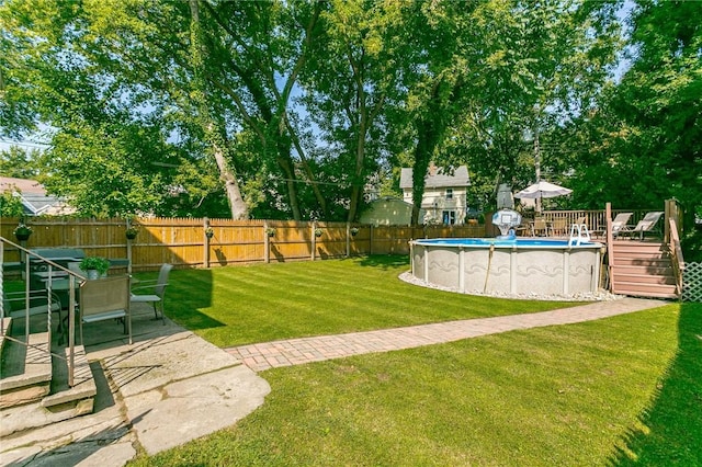 view of yard with a fenced in pool, a fenced backyard, and a deck