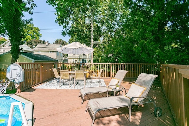 deck featuring outdoor dining space and an outdoor pool