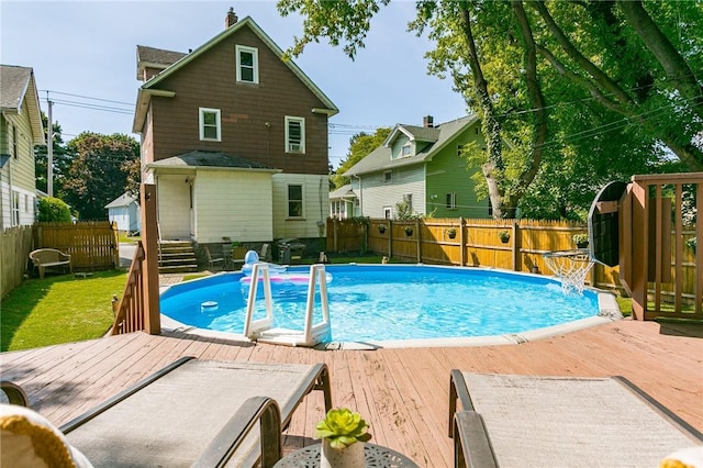 view of pool featuring a deck, a lawn, a fenced backyard, and a fenced in pool