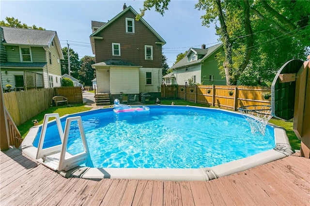 view of swimming pool with a fenced backyard, a wooden deck, and a fenced in pool