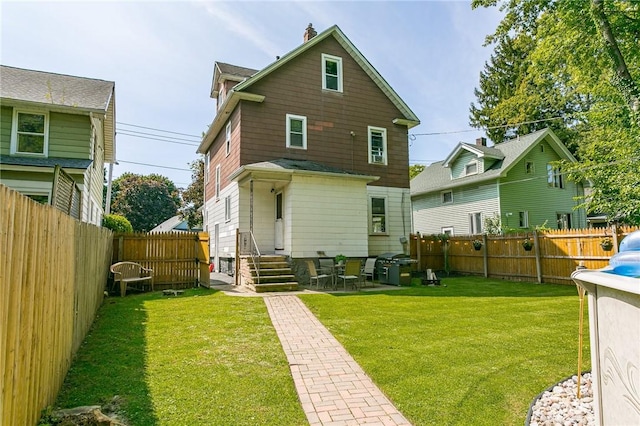 back of property featuring a fenced backyard and a yard