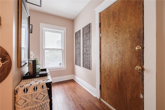 corridor with dark wood finished floors and baseboards