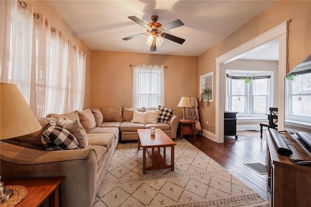 living area with a healthy amount of sunlight, light wood-style flooring, visible vents, and ceiling fan