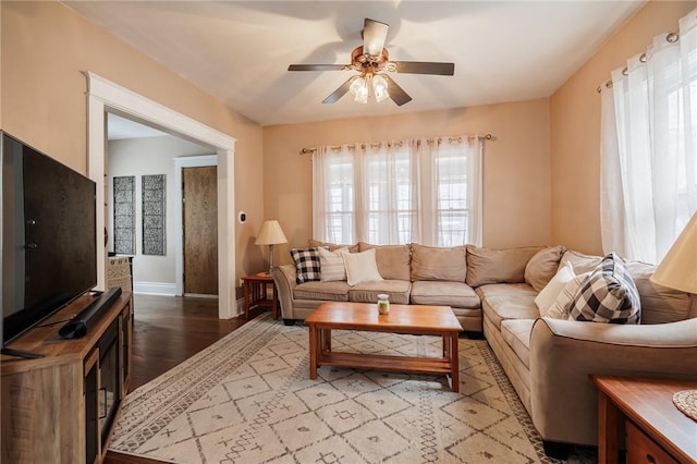 living area featuring ceiling fan, baseboards, and wood finished floors