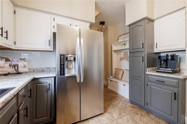 kitchen with white cabinetry, backsplash, and stainless steel fridge with ice dispenser