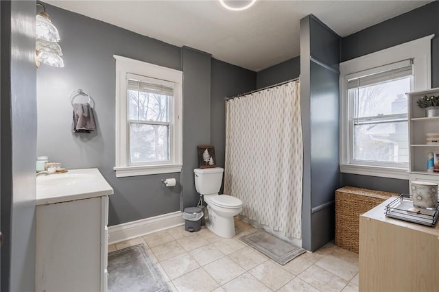 full bathroom with a shower with shower curtain, toilet, vanity, tile patterned flooring, and baseboards