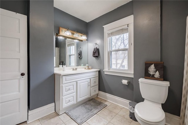 bathroom featuring baseboards, vanity, toilet, and tile patterned floors