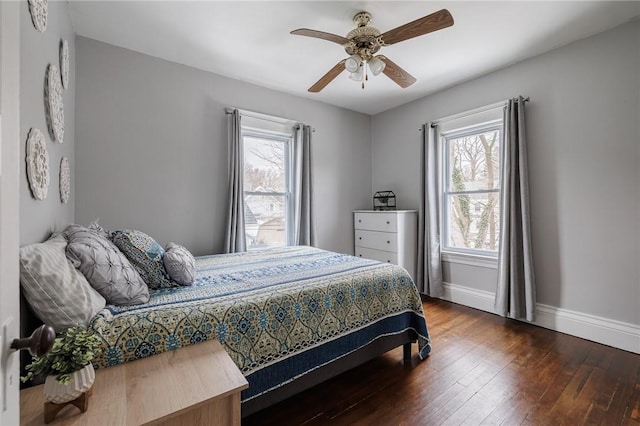 bedroom with a ceiling fan, baseboards, and dark wood-type flooring