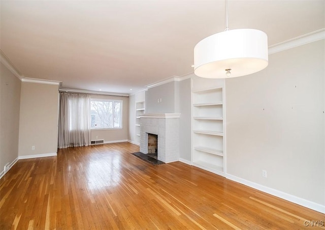 unfurnished living room featuring a fireplace, visible vents, hardwood / wood-style floors, ornamental molding, and baseboards