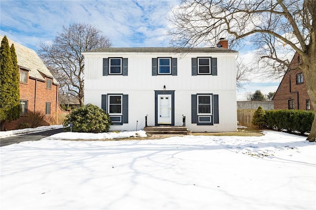 view of front of home featuring brick siding and a chimney