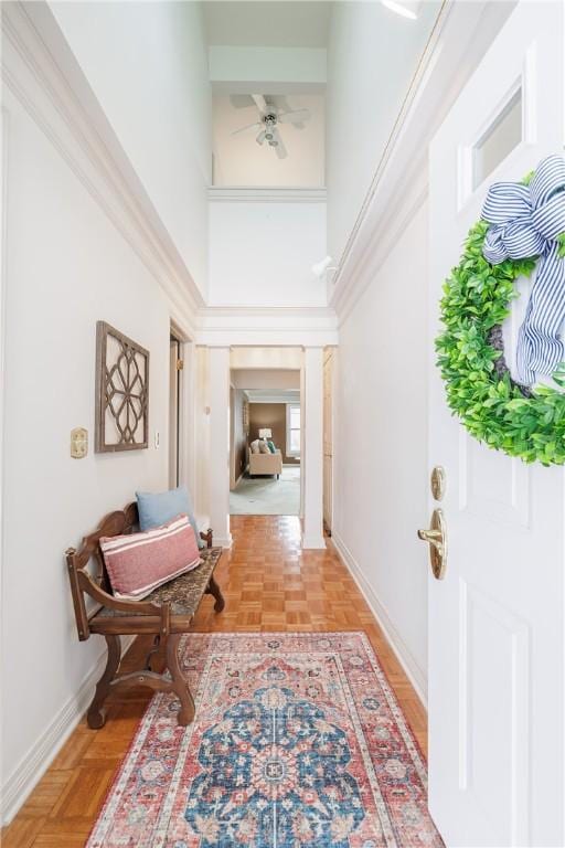 entryway with ceiling fan, a high ceiling, and baseboards