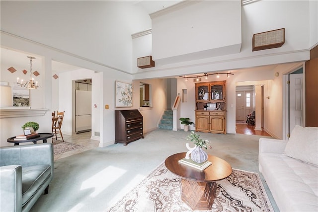 living room featuring light carpet, a towering ceiling, stairway, and a notable chandelier