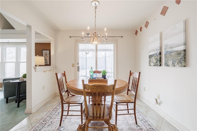 dining area featuring baseboards, an inviting chandelier, and light tile patterned floors