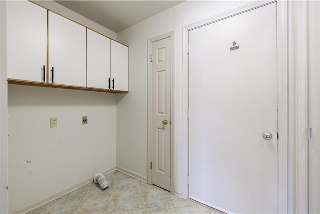 laundry room with cabinet space, electric dryer hookup, and baseboards