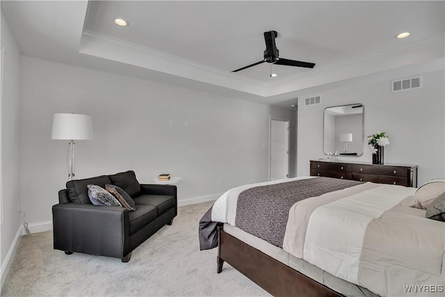 bedroom featuring light colored carpet, a raised ceiling, and visible vents