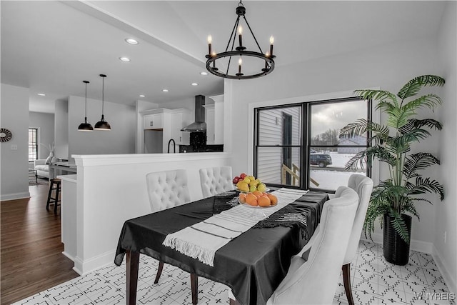 dining space featuring light wood-style floors, recessed lighting, a notable chandelier, and baseboards