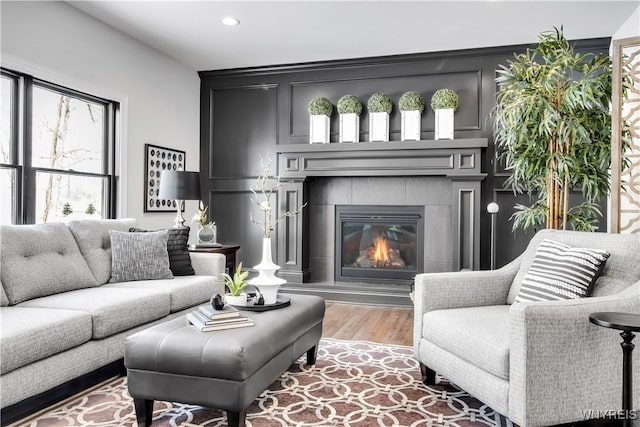 living room with a fireplace, wood finished floors, and recessed lighting