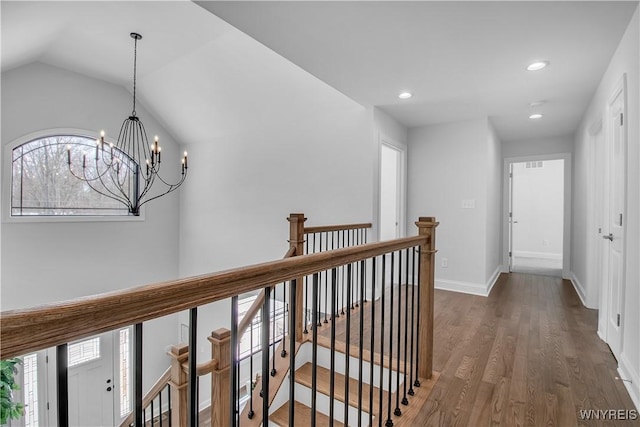 corridor with baseboards, wood finished floors, vaulted ceiling, an upstairs landing, and recessed lighting