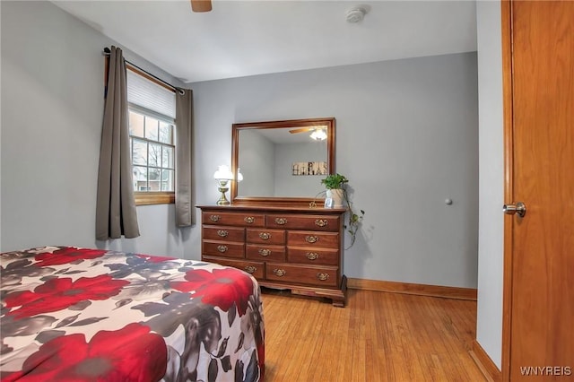 bedroom with light wood-style floors, baseboards, and a ceiling fan