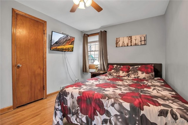 bedroom with ceiling fan, light wood-style flooring, and baseboards