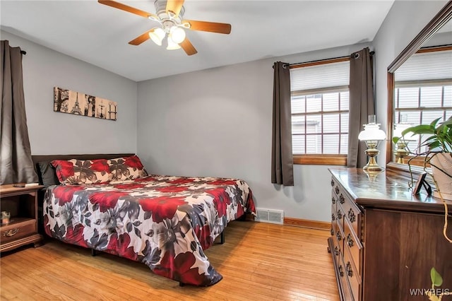 bedroom featuring baseboards, ceiling fan, visible vents, and light wood-style floors