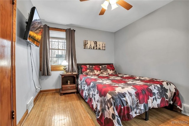 bedroom with hardwood / wood-style floors, a ceiling fan, visible vents, and baseboards