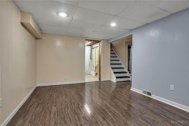 finished basement with stairway, baseboards, visible vents, and wood finished floors