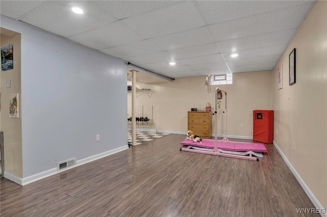 workout area with baseboards, visible vents, and wood finished floors