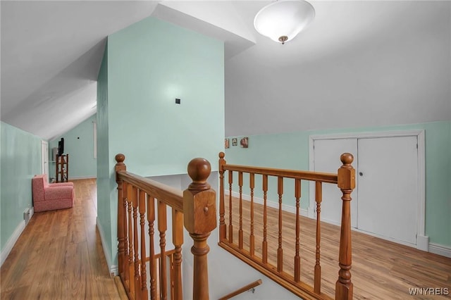 bonus room featuring baseboards, vaulted ceiling, and wood finished floors