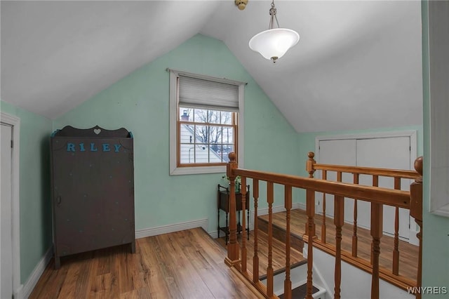 additional living space with lofted ceiling, baseboards, and wood finished floors