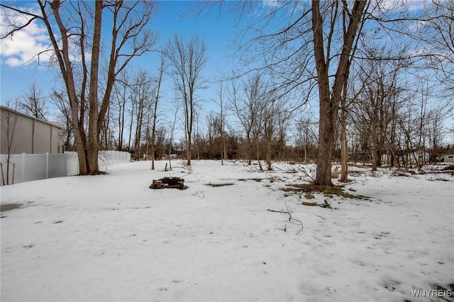 snowy yard featuring a garage and fence