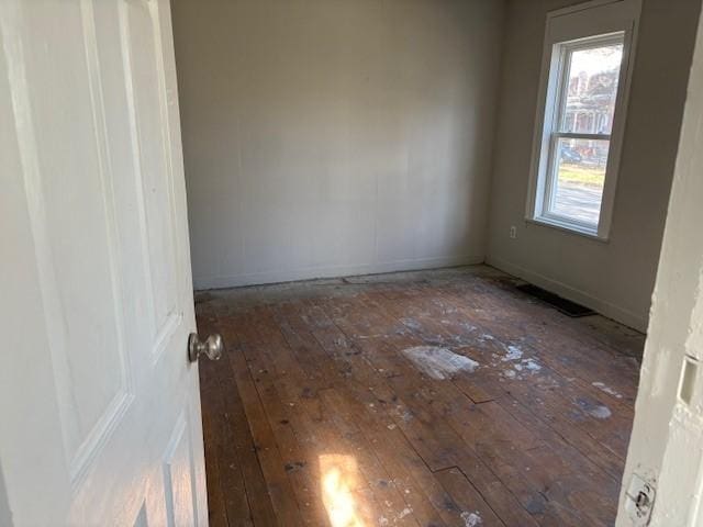 unfurnished room featuring wood-type flooring and baseboards