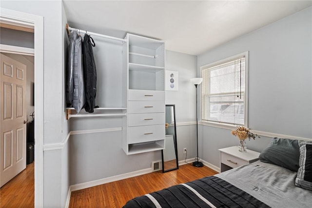 bedroom featuring wood finished floors and baseboards