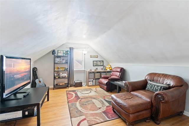 sitting room with lofted ceiling, baseboards, and wood finished floors