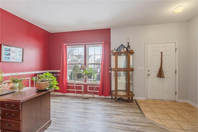 foyer entrance featuring light wood finished floors and baseboards