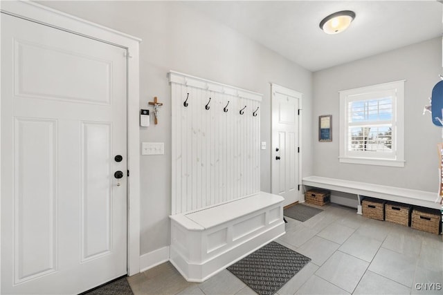 mudroom with light tile patterned flooring and baseboards