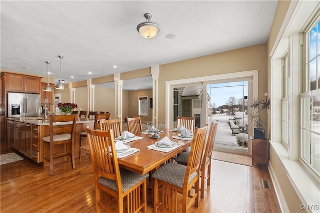 dining area with ornate columns, visible vents, wood finished floors, and recessed lighting