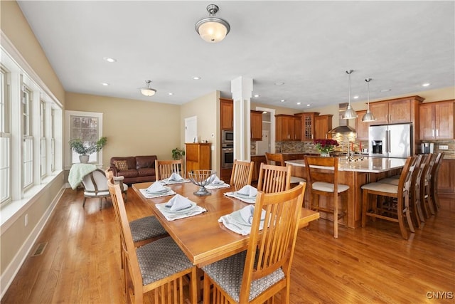 dining area with recessed lighting, decorative columns, and wood finished floors