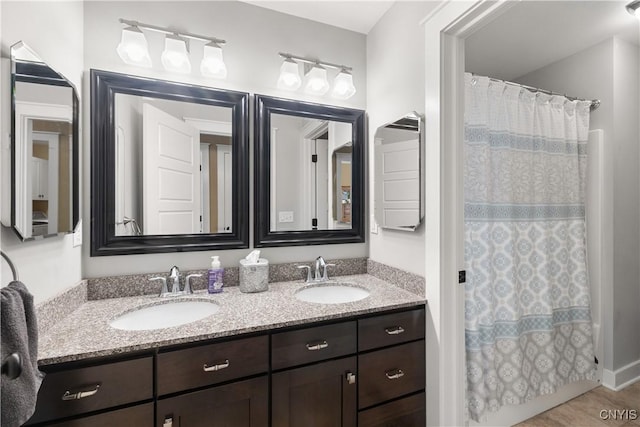 full bathroom featuring double vanity and a sink