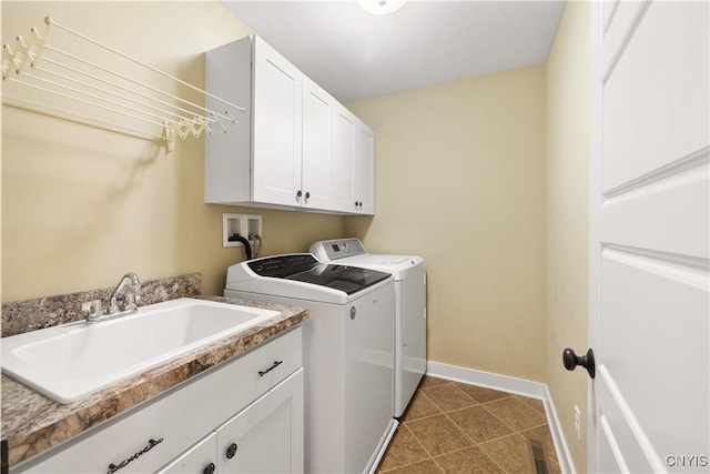 laundry area with tile patterned flooring, a sink, baseboards, cabinet space, and washing machine and clothes dryer