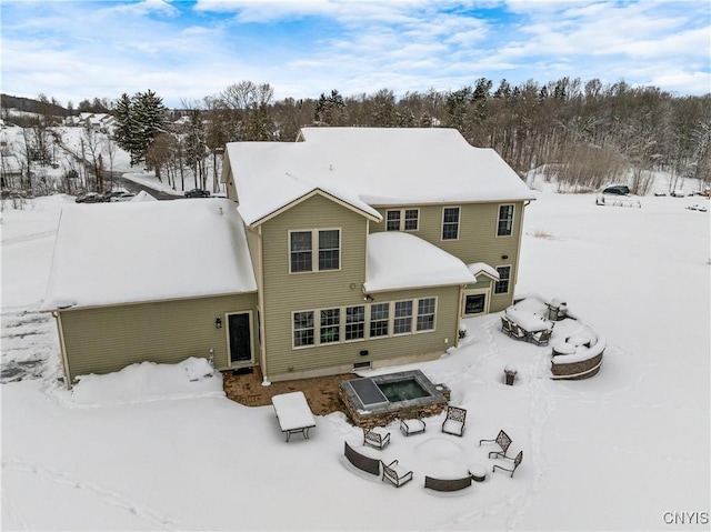 view of snow covered rear of property