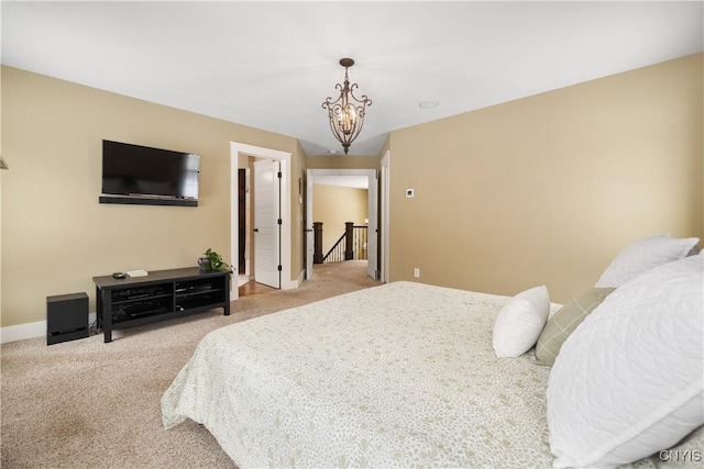 carpeted bedroom featuring an inviting chandelier and baseboards