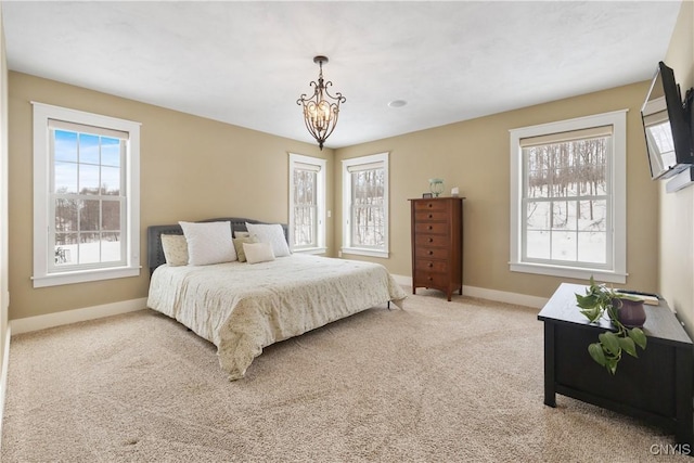 bedroom featuring a chandelier, carpet flooring, and baseboards