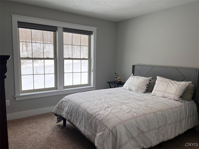 bedroom featuring baseboards and dark colored carpet